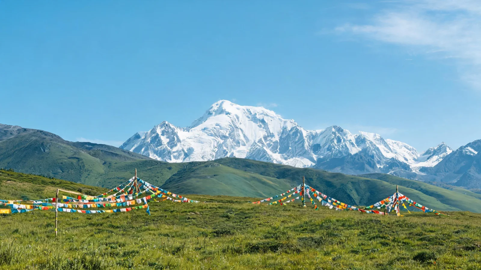 Snow-capped mountains and colorful prayer flags in Daocheng Yading, under a clear high-altitude sky